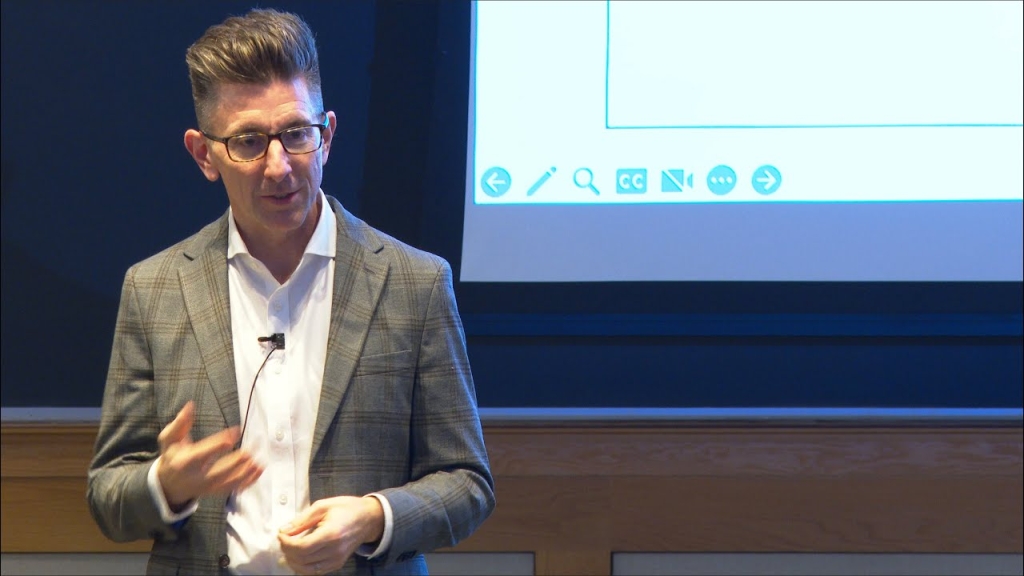 Man speaking infront of screen