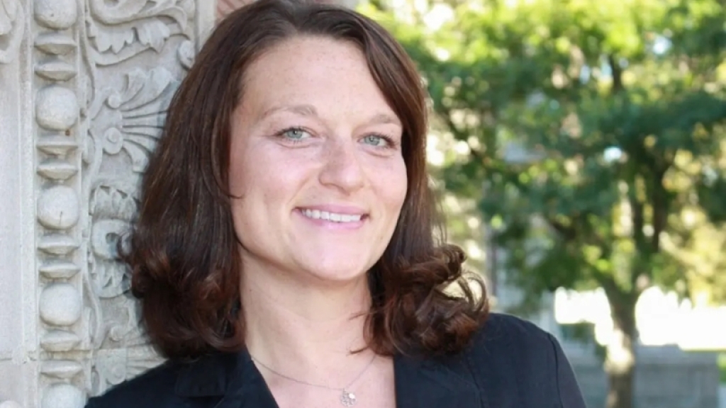 Woman with brown hair smiling at camera. 